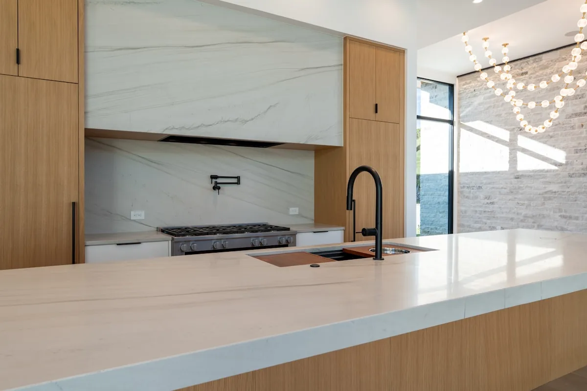 Honed marble-look countertop with a matte finish and warm wood cabinetry, Eichler-style kitchen