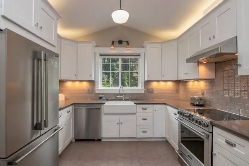 Renovated white farmhouse-style kitchen with apron-front sink and shaker cabinets