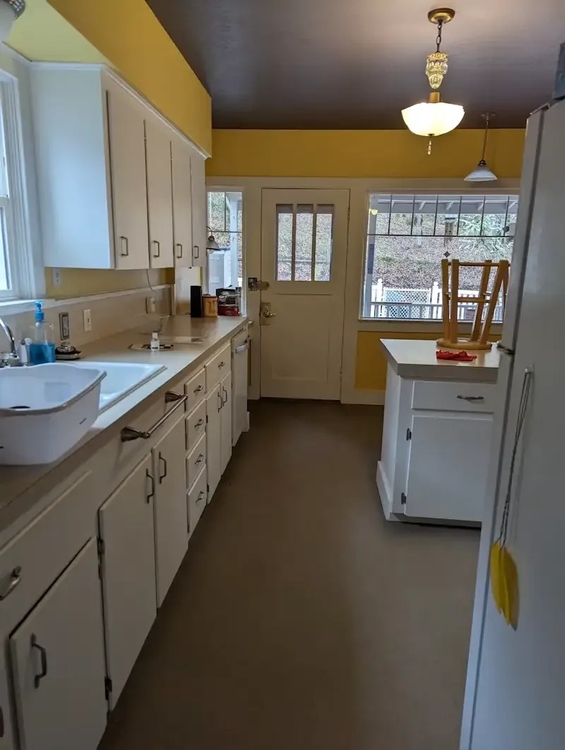 Dated kitchen with yellow walls and laminate counters before renovation