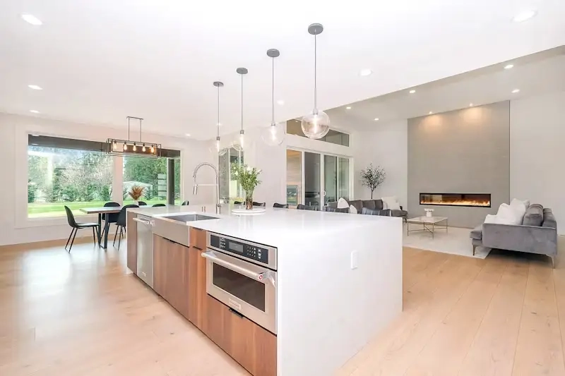Renovated open-concept kitchen opening into a living room with fireplace