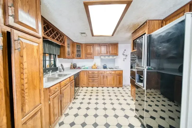 Dated oak kitchen with black-and-white checkered floor before renovation