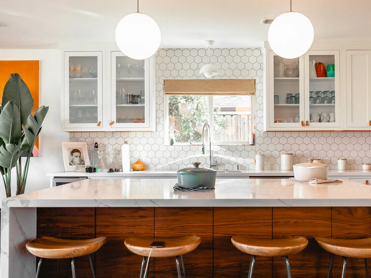 Mid-century kitchen with a walnut wood island, globe pendant lights, and hexagonal tile backsplash, Eichler-style kitchen remodel