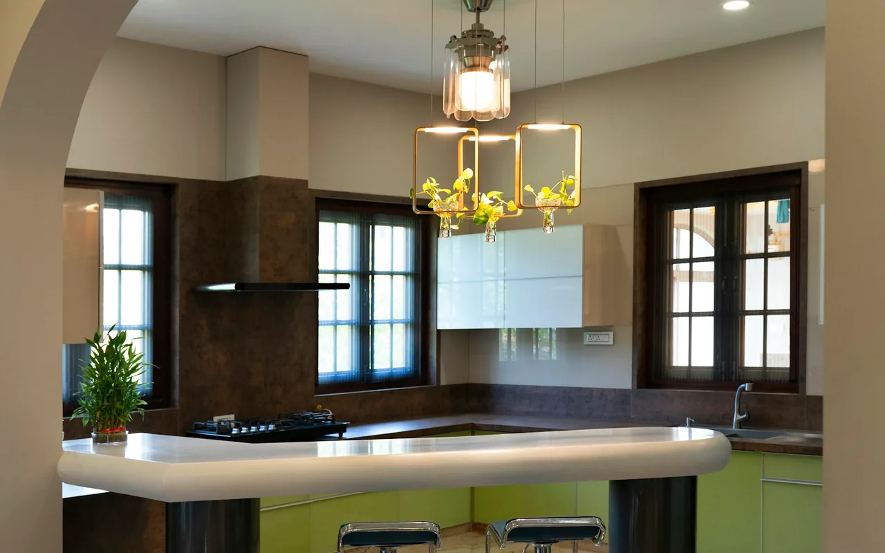 Spanish Revival-style kitchen framed by an archway, with a decorative pendant chandelier and dark wood-framed windows